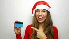 圣诞节女人持有信贷卡指出手指白色背景