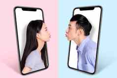年轻的夫妇接吻屏幕智能手机