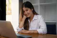 快乐的年轻的亚洲女人移动PC电脑首页学生女生活房间在线学习研究在线购物自由东盟概念