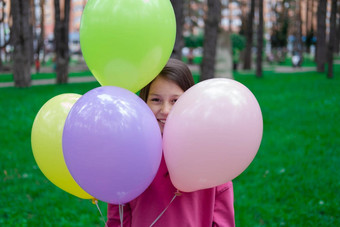 漂亮的渐变少年浅黑肤色的女人女孩粉红色的持有色彩斑斓的热空气气球在户外聚会，派对生日概念夏季快乐孩子们制裁夏天打破