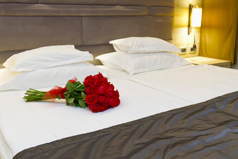 花束红色的玫瑰床上酒店房间度蜜月浪漫的会议客人酒店
