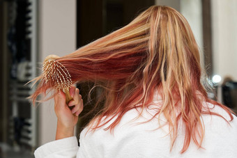 金发女郎染色头发梳理纠结的头发淋浴木梳子
