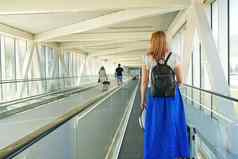 年轻的女人脸手提箱骑自动扶梯机场终端安全旅行科维德时间