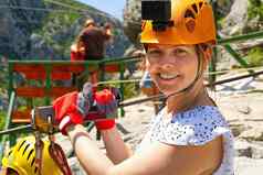 女人头盔固定行动相机准备好了下zipline山极端的体育运动活动