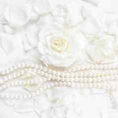 美丽的白色玫瑰花瓣珍珠项链白色背景理想的问候卡片婚礼生日情人节一天母亲的一天