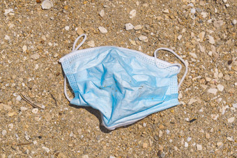 蓝色的医疗脸面具谎言海滩环境海岸塑料污染科维德大流行