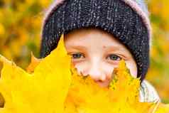 秋天情绪男孩提出了背景黄色的叶子秋天肖像孩子针织他视线可爱的微笑男孩