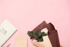 开放笔记本空白页面粉红色的背景美丽的花束玫瑰