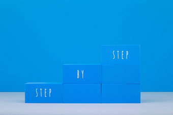 梯使蓝色的块写<strong>一步一步</strong>文本蓝色的背景复制空间