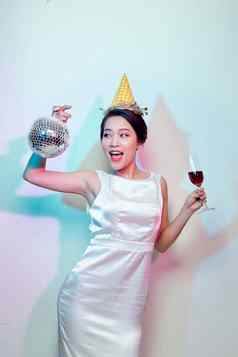 肖像快乐美丽的女人白色衣服聚会，派对喝香槟站迪斯科球孤立的光背景