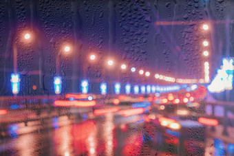 模糊的灯移动汽车灯笼反映湿沥青晚上城市雨棚窗口