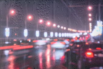 模糊的灯移动汽车灯笼反映湿沥青晚上城市雨棚窗口