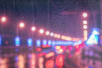 模糊的灯移动汽车灯笼反映湿沥青晚上城市雨棚窗口