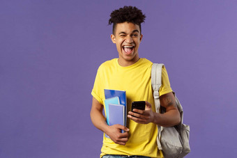 回来学校大学概念肖像快乐的微笑快乐男人。学生移动电话眨眼相机乐观的持有背包笔记本电脑笔记讲座智能手机