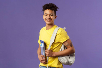 回来学校大学概念肖像英俊的有魅力的拉美裔的家伙学生走校园讲座研究持有背包笔记本电脑站紫色的背景