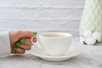 修剪整齐的女手时尚的绿色指甲持有杯咖啡打破咖啡拿铁时尚的现代设计修指甲过来这里指甲皮肤护理美指甲护理