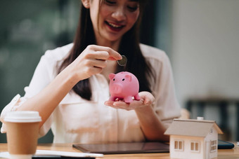 抵押贷款投资真正的房地产财产概念关闭女人把钱粉红色的小猪银行贷款保存买房子