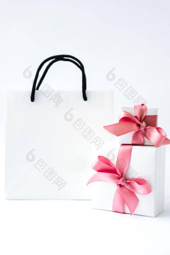 空<strong>白纸</strong>白色袋礼物现在盒子粉红色的丝带白色背景黑色的星期五出售购物概念模型纸购物袋