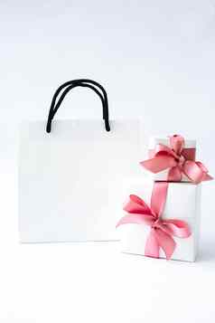 空白纸白色袋礼物现在盒子粉红色的丝带白色背景黑色的星期五出售购物概念模型纸购物袋