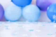 摘要散焦模糊节日背景假期生日男孩女孩聚会，派对概念婴儿淋浴蓝色的气球五彩纸屑