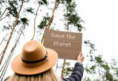 女手持有纸板文本保存地球在户外自然背景抗议者积极分子