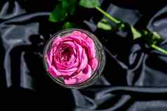 酒玻璃填满粉红色的花petalson表格黑色的丝绸织物最小的现代生活假期概念情人节女士一天背景设计