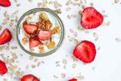 健康的早餐燕麦片格兰诺拉麦片希腊酸奶坚果草莓牛奶什锦早餐罐子光背景素食主义者素食者重量损失饮食概念排毒菜单