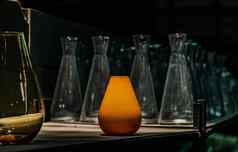 显示黄色的玻璃花瓶架子上玻璃器皿仓库概念室内设计装饰