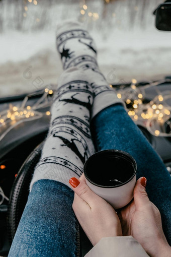 女人腿<strong>袜子</strong>手持有热水瓶杯咖啡茶冬天车圣诞节<strong>袜子</strong>加兰散焦灯