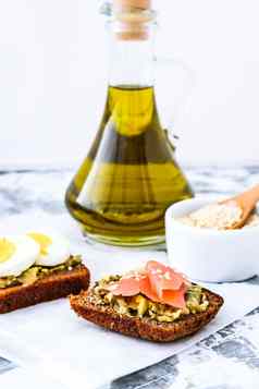烤面包挖走鸡蛋鳄梨大马哈鱼鳄梨色拉酱三明治健康的早餐橄榄石油芝麻种子素食者健康的吃