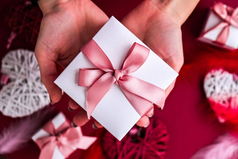 平躺女人手持有现在盒子装饰粉红色的丝带红色的背景快乐情人节一天圣诞节母亲的女人的一天