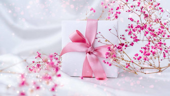 白色现在盒子粉红色的丝带小粉红色的花白色丝绸织物背景问候卡假期