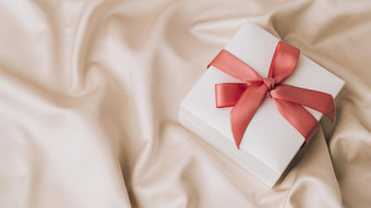 礼物盒子粉红色的丝带白色织物丝绸背景前视图最小的现在复制空间