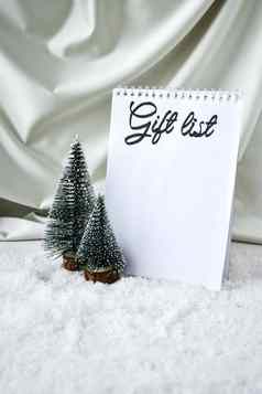 笔记本礼物列表文本圣诞节树香槟彩色的丝绸背景白色雪时尚的装饰圣诞节假期庆祝活动一年概念问候卡