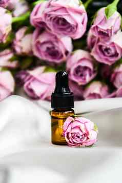 玫瑰石油水疗中心芳香疗法玫瑰花至关重要的石油瓶吸管缎香槟颜色织物瓶玫瑰至关重要的石油新鲜的花