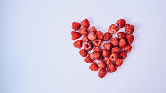 美丽的红色的心雕刻许多树莓铺设<strong>纯白色</strong>背景
