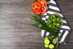 切片生黄瓜西红柿莱图尔绿色洋葱碗准备素食主义者健康的沙拉排毒低卡路里饮食