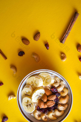 成分健康的早餐燕麦片香蕉腰果坚果杏仁肉桂黄色的背景复制空间文本