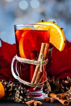 圣诞节喝眼镜热加香料的热酒橙子茴香肉桂红色的一品红花