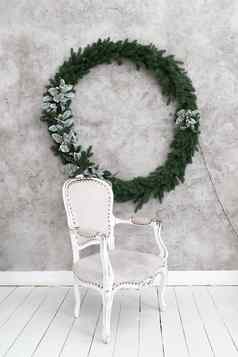 圣诞节室内房间灰色的椅子站光墙挂起圣诞节花环绿色针叶树花环装饰银叶子加兰高质量照片
