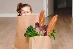 女孩坐着纸袋隐藏蔬菜面包杂货店复制空间