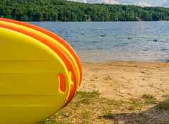 堆栈黄色的橙色paddleboards桑迪海滩湖