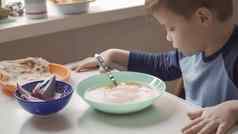 年轻的男孩吃汤坐着餐厅房间表格