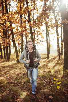 年轻的男人。背包旅行秋天森林阳光明媚的温暖的一天微笑高加索人旅游走自然徒步旅行概念