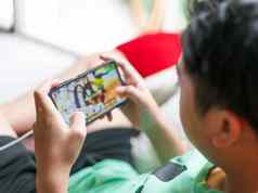 手孩子持有智能手机玩游戏在线首页