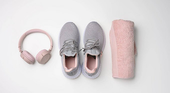 一对灰色的纺织运动鞋无线耳机纺织粉红色的毛巾白色背景<strong>集体</strong>育运行