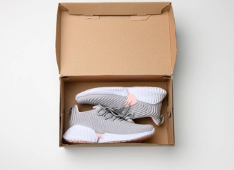 一对灰色的纺织运动鞋开放棕色（的）纸盒子白色表格