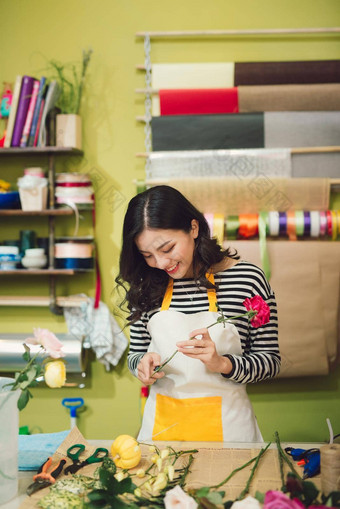 可爱的集中年轻的女花店工作花商店