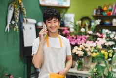 年轻的英俊的花店写作订单会说话的移动电话花商店