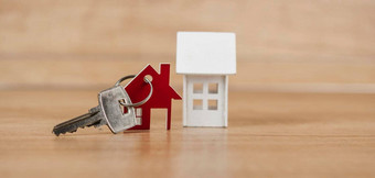 关键房子形状的钥匙链安排木背景真正的房<strong>地产</strong>保险概念抵押贷款买出售房子房<strong>地产</strong>经纪人概念